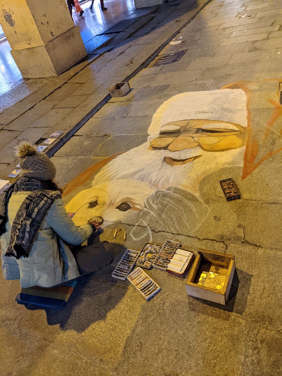 An artist making a chalk drawing of Santa Claus