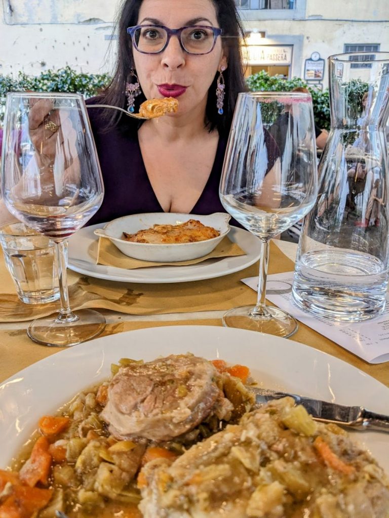 Photo of Teresa enjoying her lasagna, with my osso bucco in the foreground.