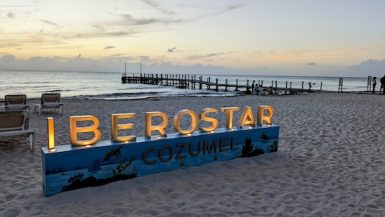 Lighted sign on the beach that says "Iberostar"