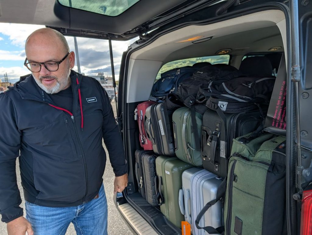 Dražen standing next to our luggage, perfectly stacked in the back of the van.