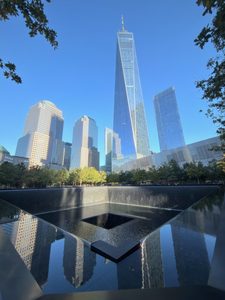 Blue sky reflecting on the polished stone and water of the World Trade Center Memorial